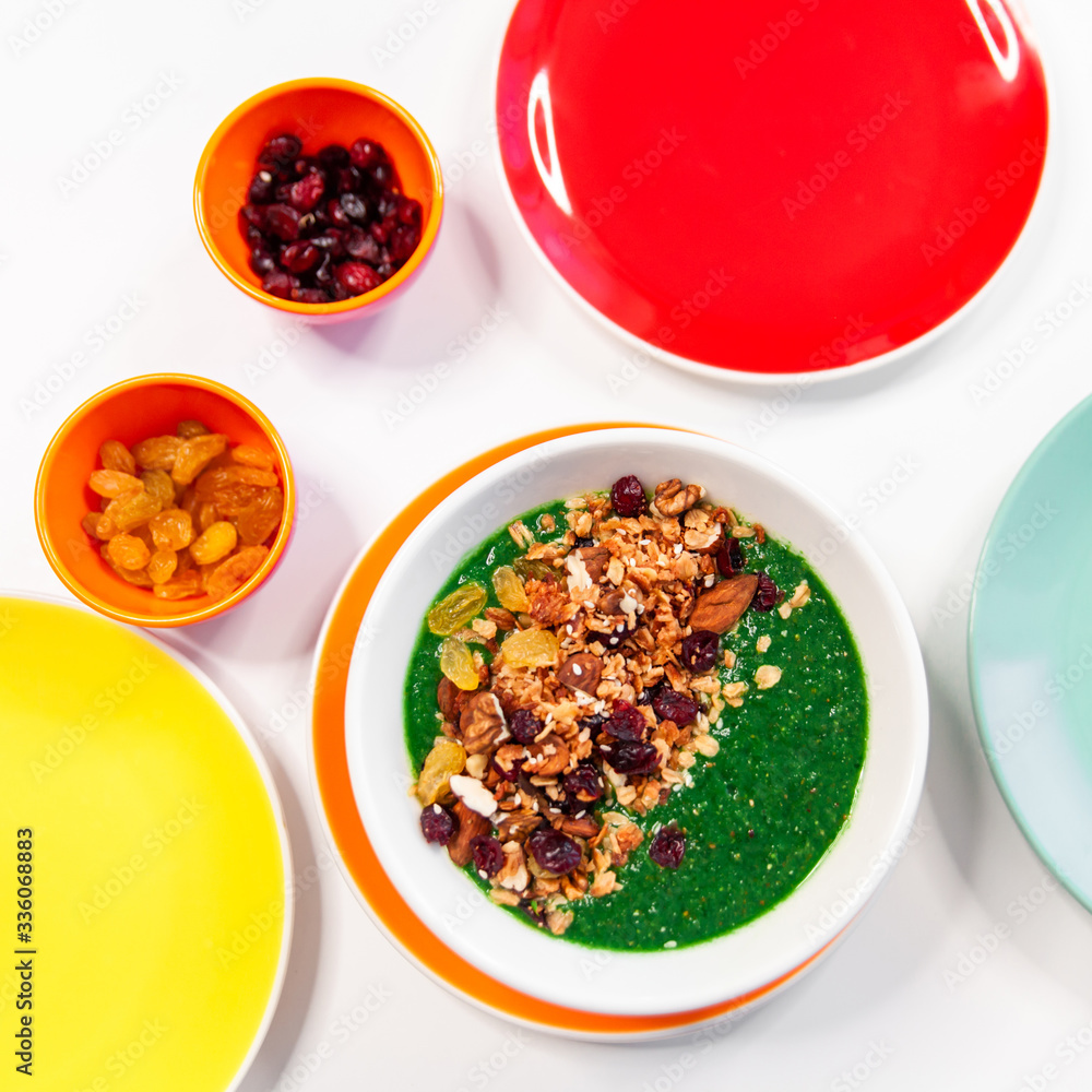 fresh greens and granola smoothie on white table. Healthy vegan food. fresh greens and granola smoothie on white table. Healthy vegan food.