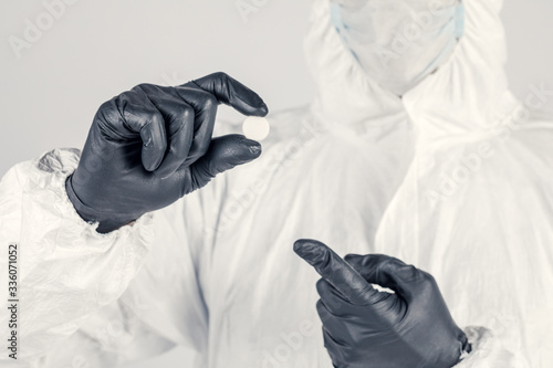 A tablet in the hand of a man close-up, a man in a medical mask holding medicine. Concept of medicine and public health