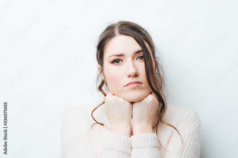 girl on a white background props chin fist