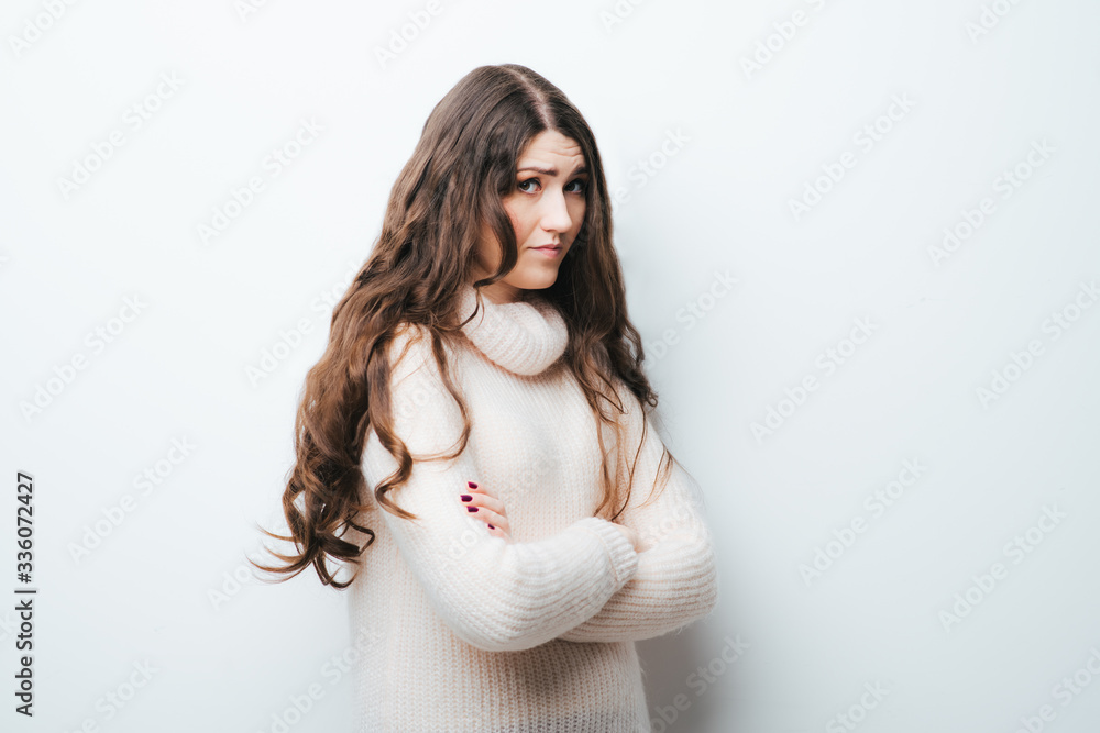 Obraz premium Young businesswoman is standing and folding her arms on her chest. The friendly woman is looking at the camera and smiling.