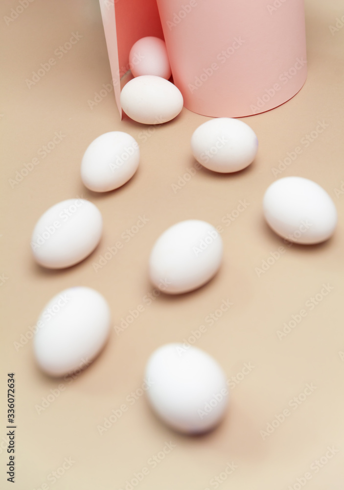 Creative Easter beige and pink background with white eggs.