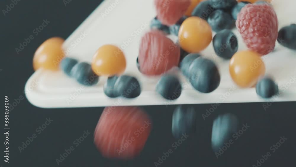 Different berries falling down a chopping board Different berries falling down a chopping board