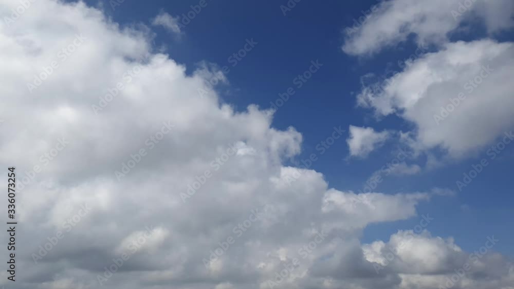 Blue summer sky with dense thick rain clouds moving across the heavens. Fast cloud formation and movement creating a surreal time lapse. Blue summer sky with dense thick rain clouds moving across the heavens. Fast cloud formation and movement creating a surreal time lapse.
