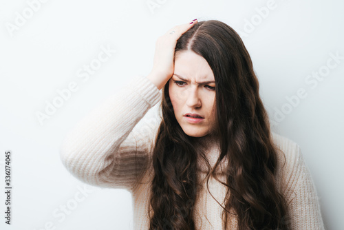 on a white background a young girl with long hair headache