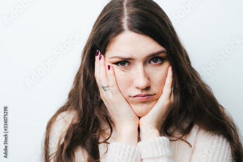 on a white background young girl with long hair sad