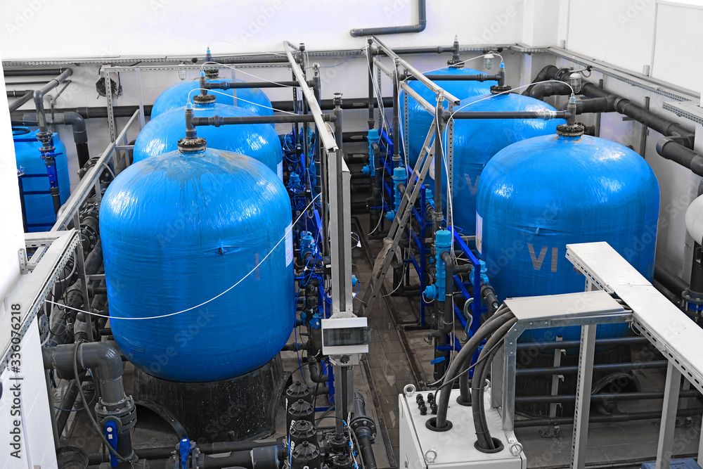 many big blue water tanks inside wastewater treatment facility, industrial interior inside many big blue water tanks inside wastewater treatment facility, industrial interior inside