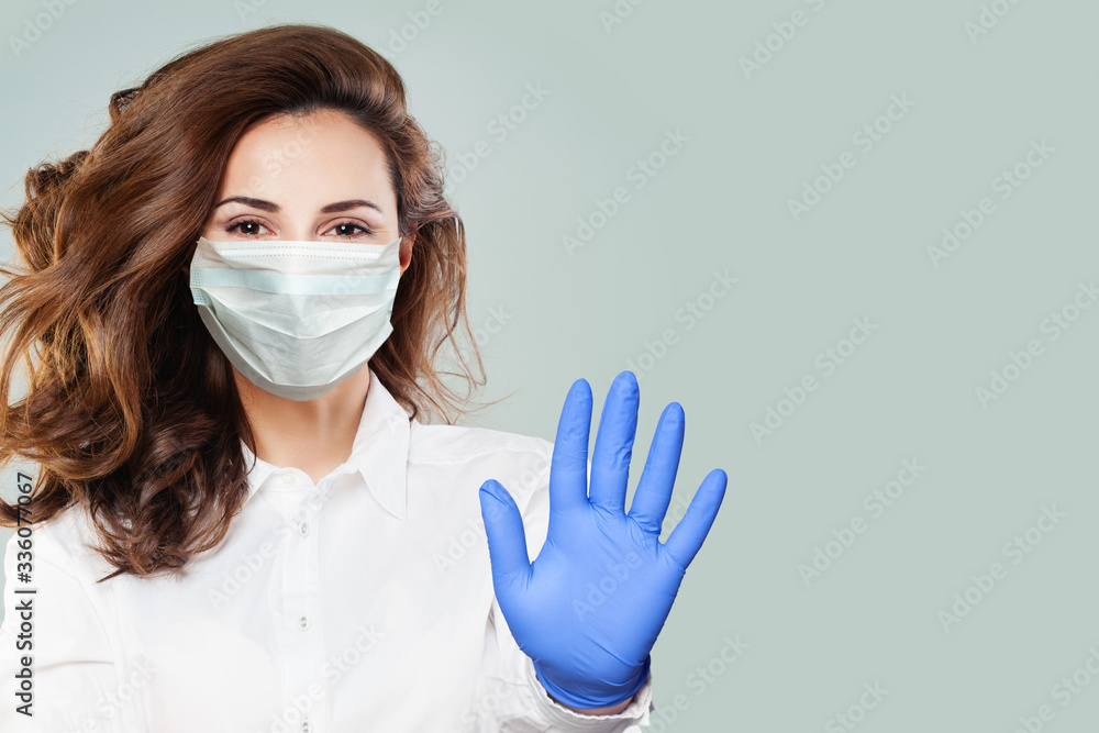 Confident doctor or nurse wearing a medical face mask showing stop pandemic gesture. Woman in safety mask and medical gloves. Virus protection concept Confident doctor or nurse wearing a medical face mask showing stop pandemic gesture. Woman in safety mask and medical gloves. Virus protection concept