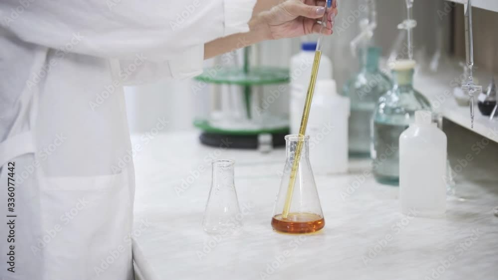 Female scientist with pipette analyzes liquid in distillery laboratory