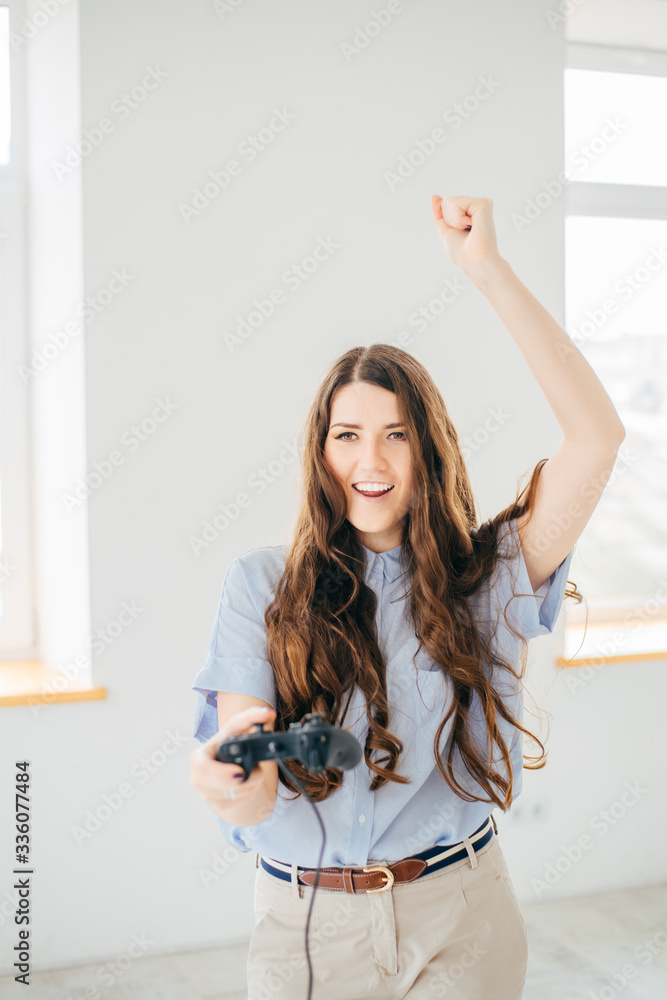 Happy woman playing video game near the window at home Happy woman playing video game near the window at home