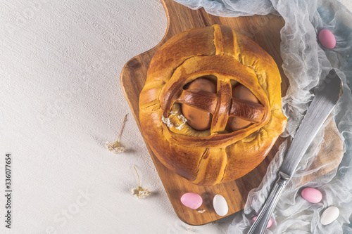 Portuguese traditional Easter cake. Folar with eggs on wooden table photo