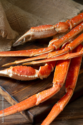 Crab meat on a dark brown Board on a brown wooden table. Dark background. Still life with crab