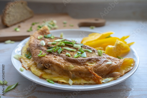 Fried omelette with whole grain bread, cheese, green onion and yellow fresh raw pepper, healthy food for breakfast
