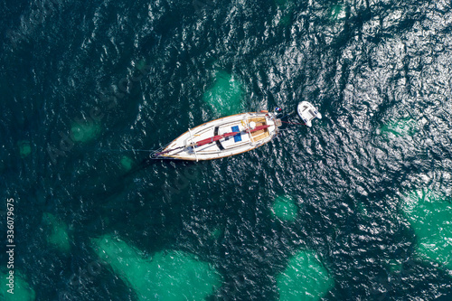 Aerial drone top-down photo of of a boat in Costa Brava coast and crystal clear waters