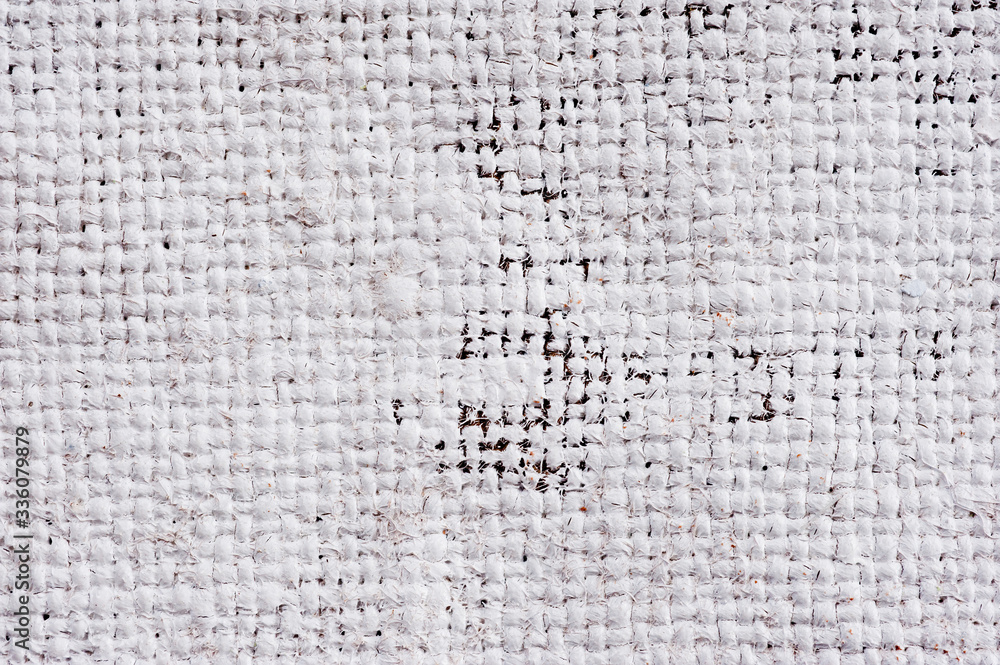Closeup texture of a roughly painted white and light green canvas lying on a wooden surface. Background for fabric texture. Universal background. Closeup texture of a roughly painted white and light green canvas lying on a wooden surface. Background for fabric texture. Universal background.
