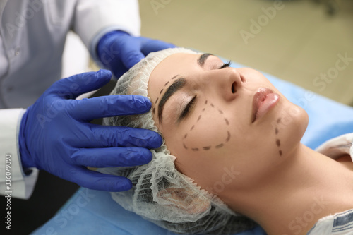 Doctor preparing female patient for cosmetic surgery in clinic
