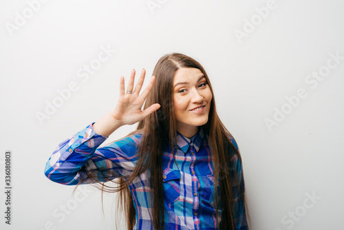 young woman waving, smiling