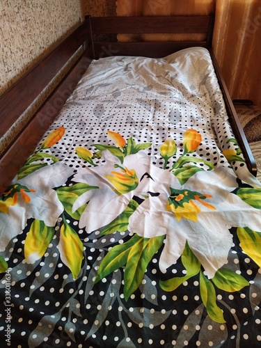 Foto Made-up wooden baby bed in bedroom