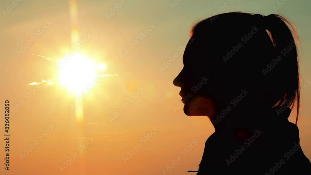 Silhouette of a girl drinking water from a bottle at sunrise. Silhouette of a girl drinking water from a bottle at sunrise.