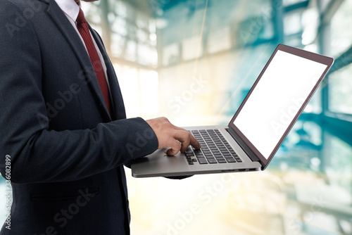 Double exposure of a businessman using a laptop cityascape and network concept
