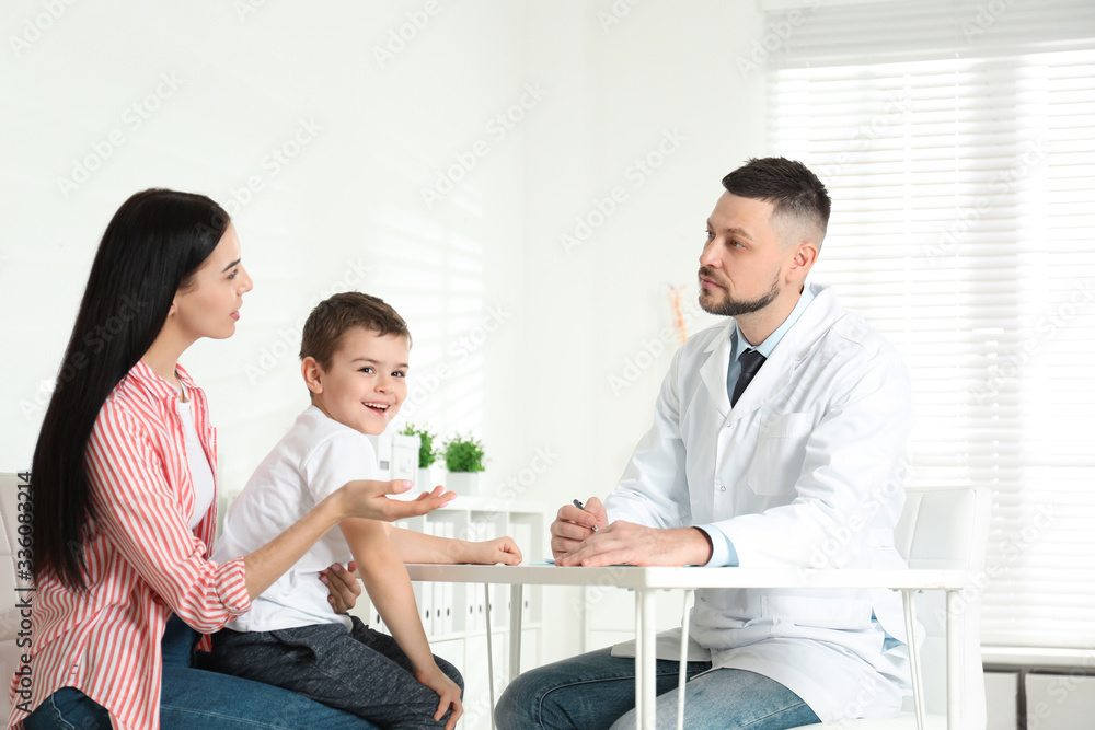 Fototapeta premium Little boy with mother visiting orthopedist at clinic