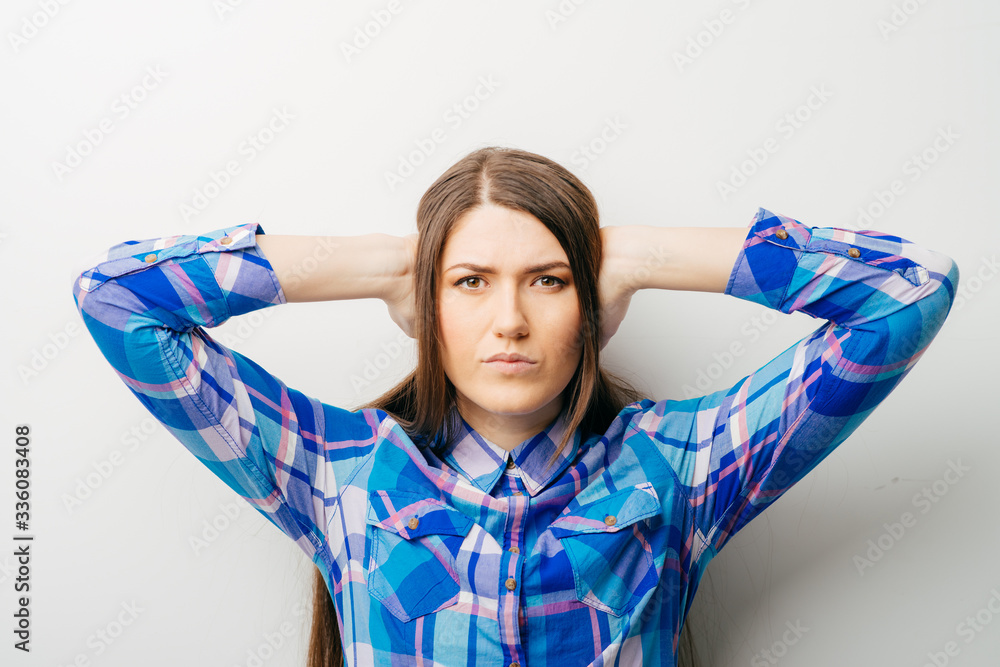 Portrait of young woman covering with hands her ears, isolated over white background Portrait of young woman covering with hands her ears, isolated over white background