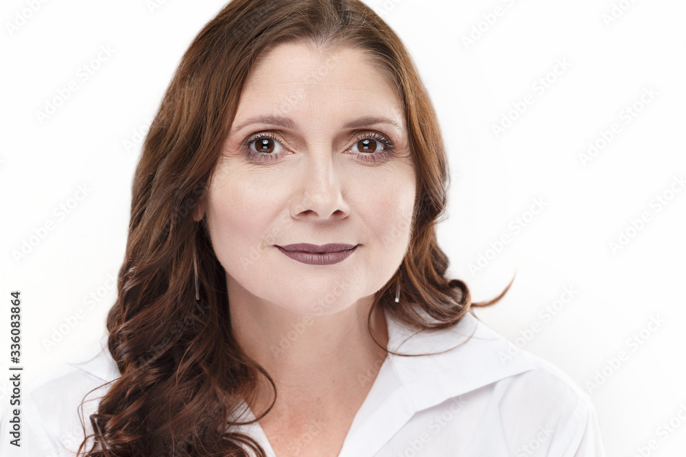 Middle aged 50+ woman in white shirt confidently looking ahead in spokeswoman headshot Middle aged 50+ woman in white shirt confidently looking ahead in spokeswoman headshot