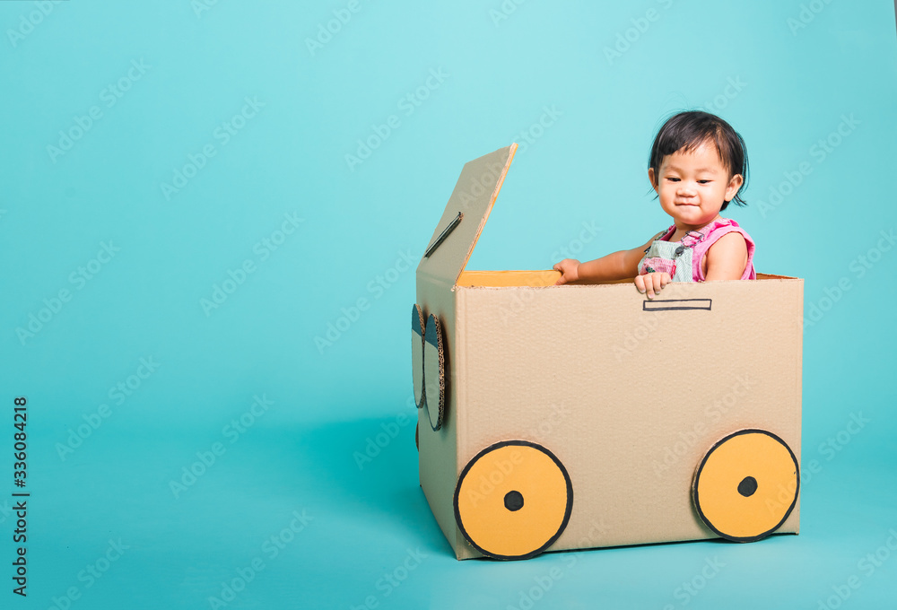 Baby girl smile in driving play car creative by a cardboard box Baby girl smile in driving play car creative by a cardboard box