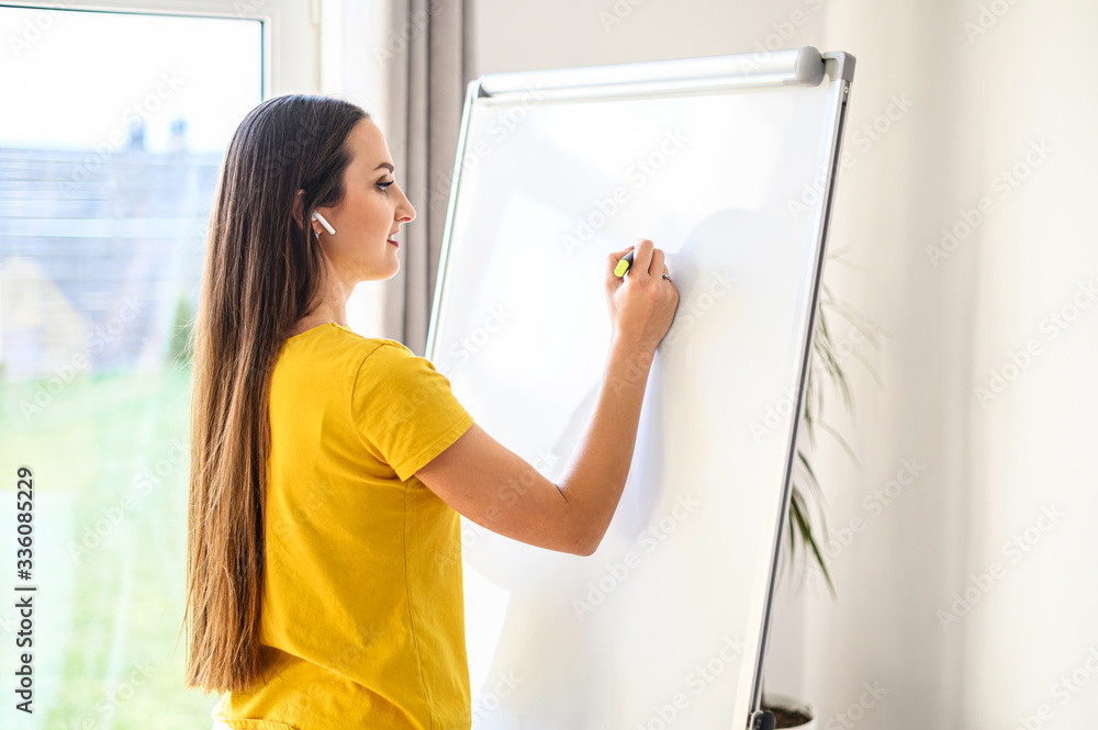 Woman with a marker making notes on a white board