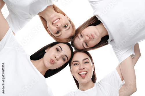 Beautiful young ladies hugging on white background, bottom view. Women's Day