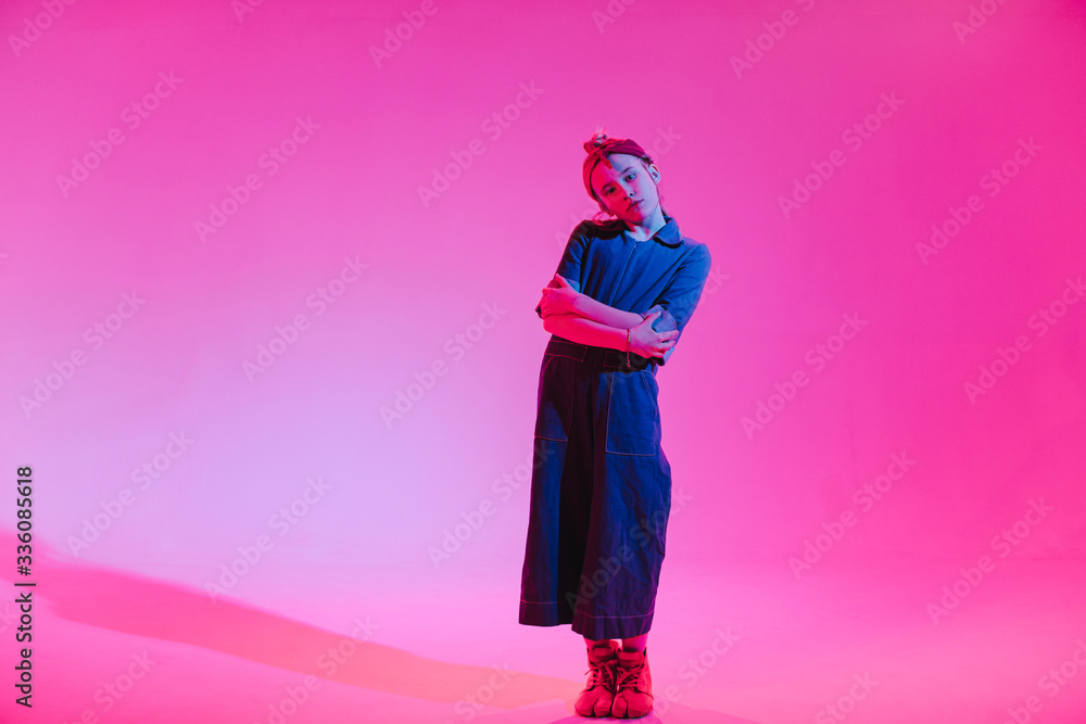 Young stylish girl dancing in the Studio on a colored neon background. Music dj poster design.