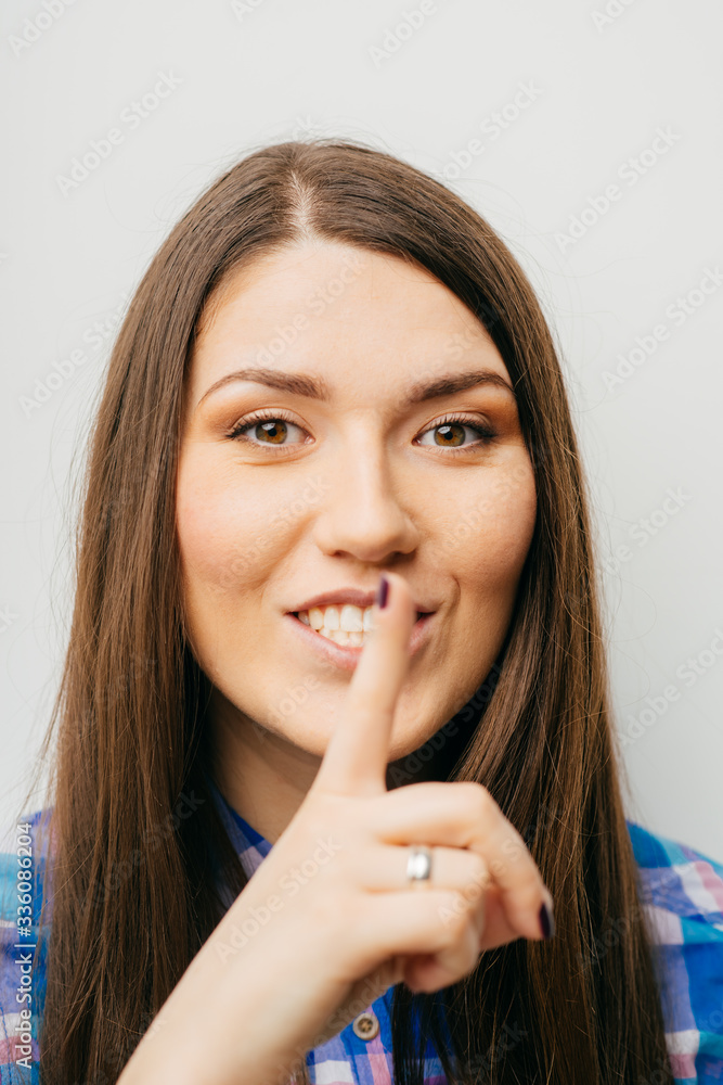 long-haired beautiful girl showing quietly finger, isolated on white background long-haired beautiful girl showing quietly finger, isolated on white background