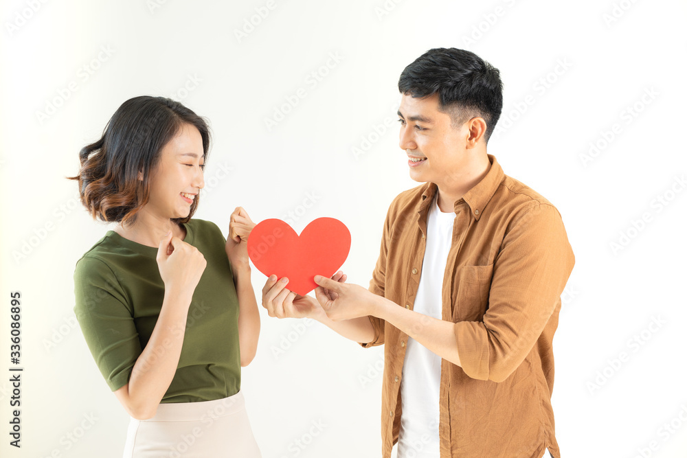 Smiling loving couple holding heart shape over white background. Smiling loving couple holding heart shape over white background.