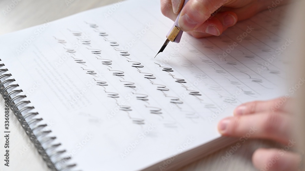 a girl fills a calligraphy notebook with beautiful symbols a girl fills a calligraphy notebook with beautiful symbols