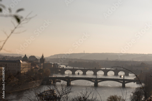 stone bridges of the city of Prague at sunset, cross the Vltava river, with cold and dark water, European architecture