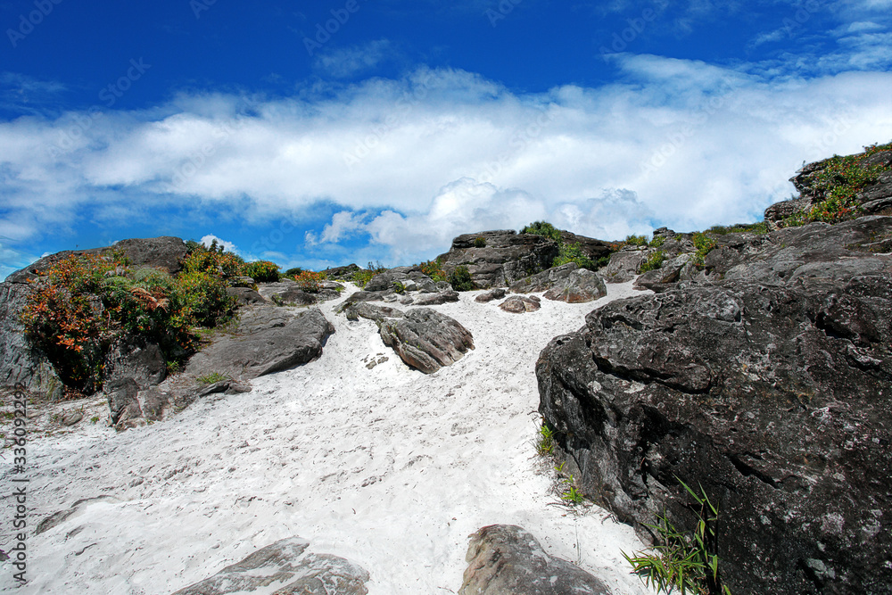 View of Mountain Rock with White Sand and white clouds in wamena