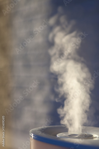 Humidifier spreading steam with white brick background.