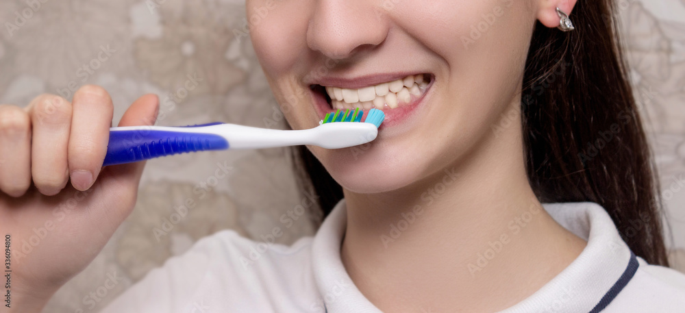 Brushing teeth with toothbrush close-up. Dental hygiene and teeth care. oral care, dental hygiene and people concept - close up of smiling woman with toothbrush cleaning teeth over background Brushing teeth with toothbrush close-up. Dental hygiene and teeth care. oral care, dental hygiene and people concept - close up of smiling woman with toothbrush cleaning teeth over background