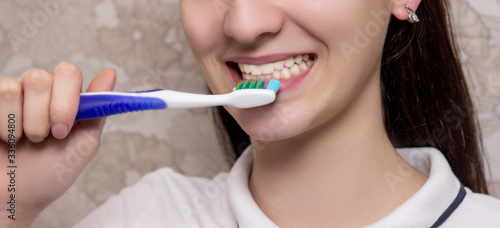 Brushing teeth with toothbrush close-up. Dental hygiene and teeth care. oral care, dental hygiene and people concept - close up of smiling woman with toothbrush cleaning teeth over background
