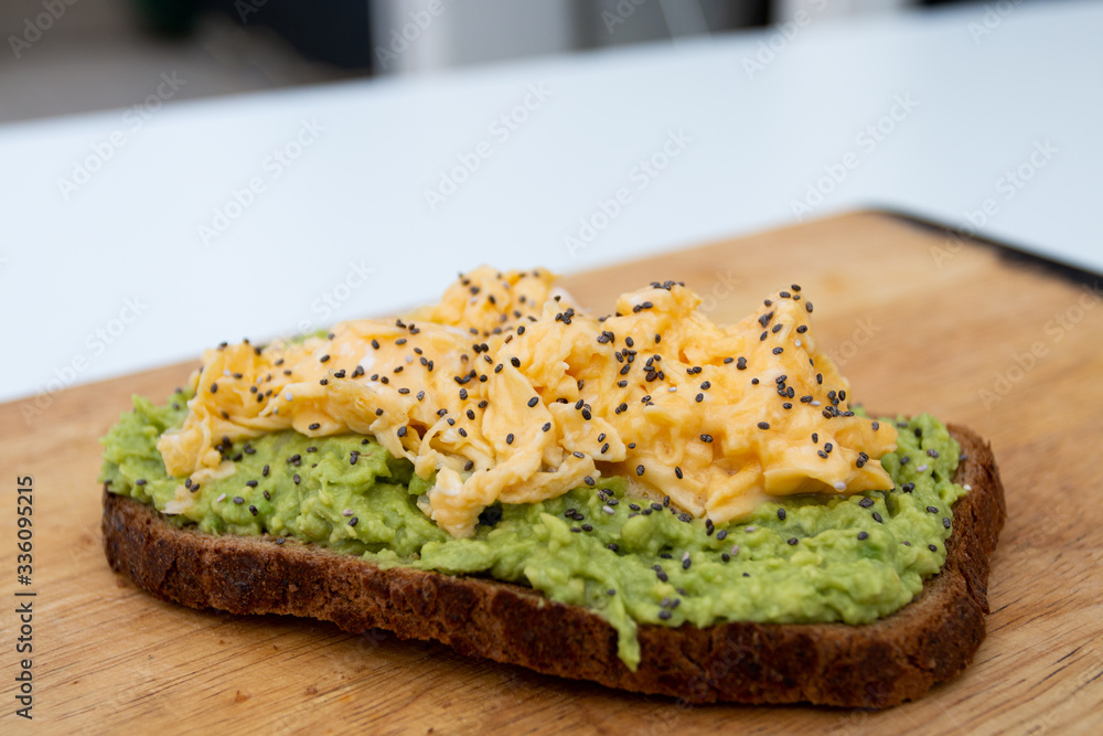whole wheat toast with guacamole and omelette on top of a wood
