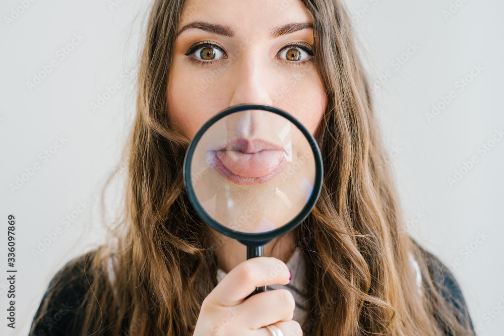 Girl with a magnifying glass in front of her mouth Girl with a magnifying glass in front of her mouth
