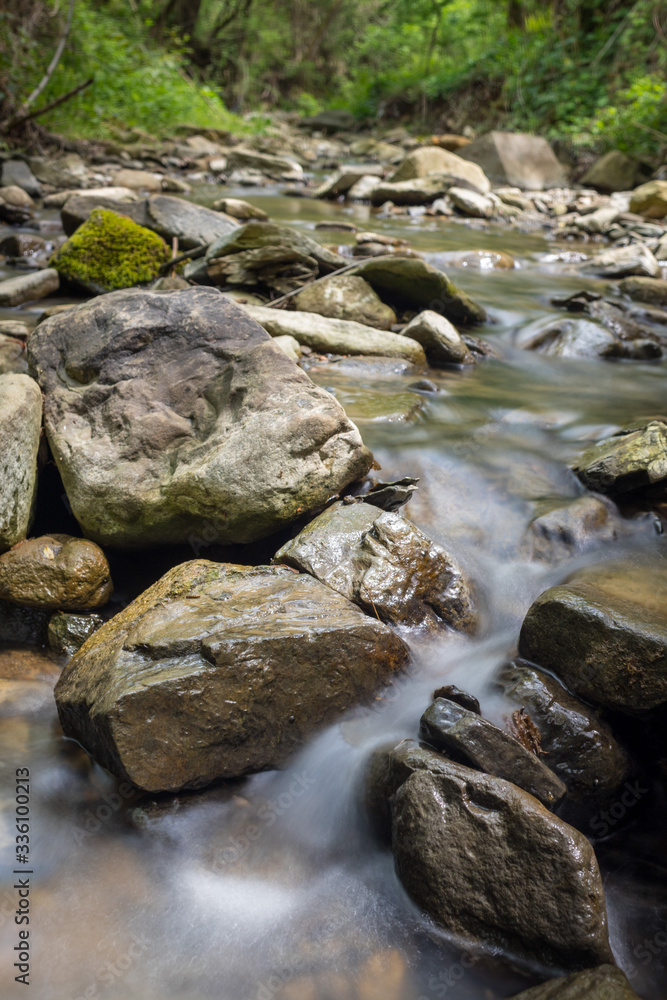 Photo of nature - Long exposure of a mountain stony creek inside in the forest. Small mountain rocky river. Photo of nature - Long exposure of a mountain stony creek inside in the forest. Small mountain rocky river.
