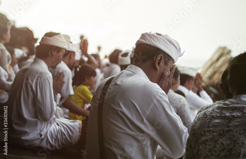 Indonesian people pray near the temple Pura Tanah Lot. Bali. Indonesia photo