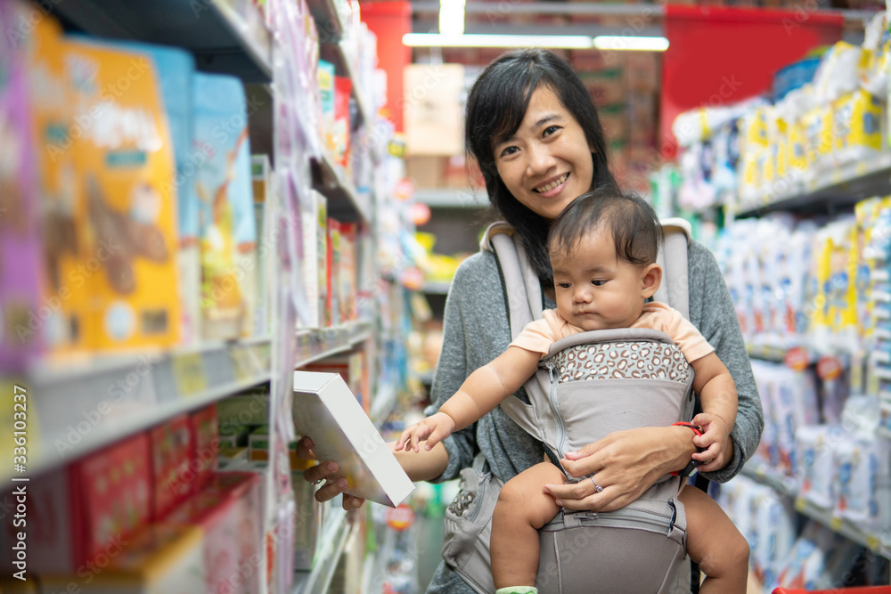 asian Mother and baby shopping in the supermarket. grocery store shopping
