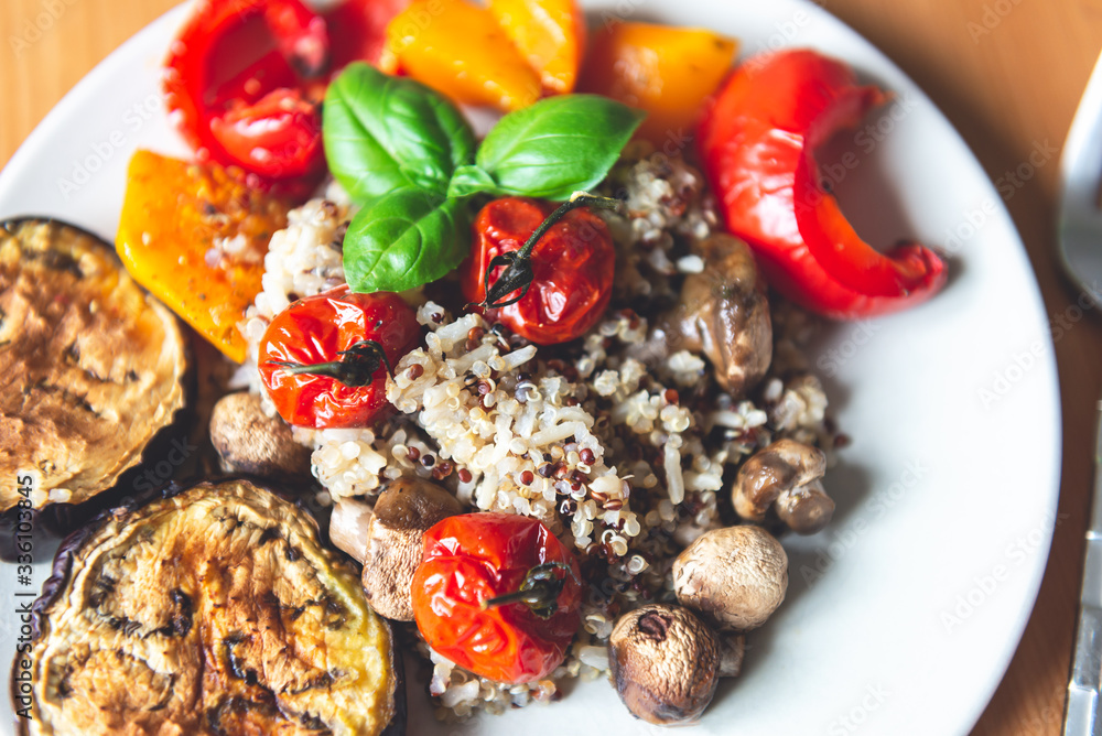 Fototapeta premium Simple Healthy Detox Dinner from quinoa and different roasted vegetables such as aubergine, red pepper, cherry tomatoes, butternut squash