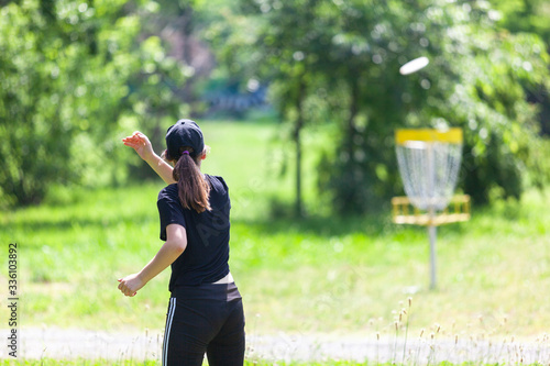 Young woman playing flying disc sport game in the park