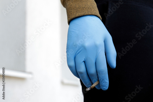 Man in protective gloves with cigarette. Covid-19 daily life. Protect from corona virus and smoking. Smokers facing higher risk of severe symptoms caused by corona virus. 