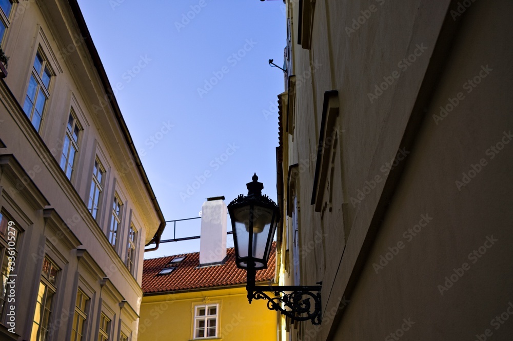 Isolated black street lantern hanging on the wall in a narrow street (Prague, Czech Republic, Europe)