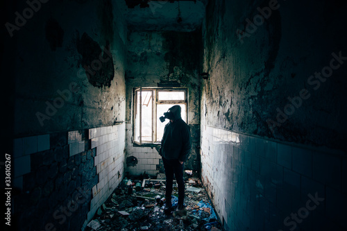 Dramatic portrait of a man wearing a gas mask in a ruined building.  © belyaaa