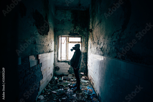 Dramatic portrait of a man wearing a gas mask in a ruined building. 