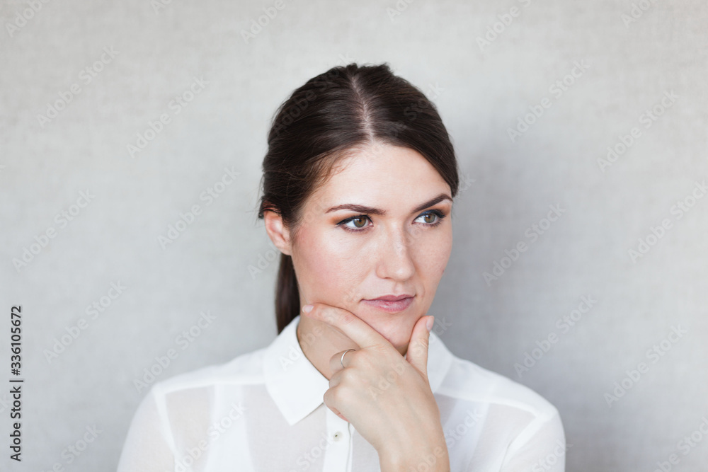 Closeup portrait of pretty mad young woman, finger on lips, daydreaming something serious and upsetting. Human facial expressions, emotions, feelings, signs, symbols Closeup portrait of pretty mad young woman, finger on lips, daydreaming something serious and upsetting. Human facial expressions, emotions, feelings, signs, symbols